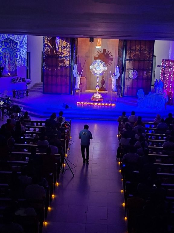 Adoración al Santísimo en el templo iluminado de azul