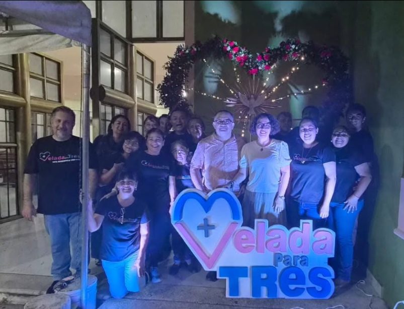 Equipo de la Velada para Tres junto al letrero luminoso