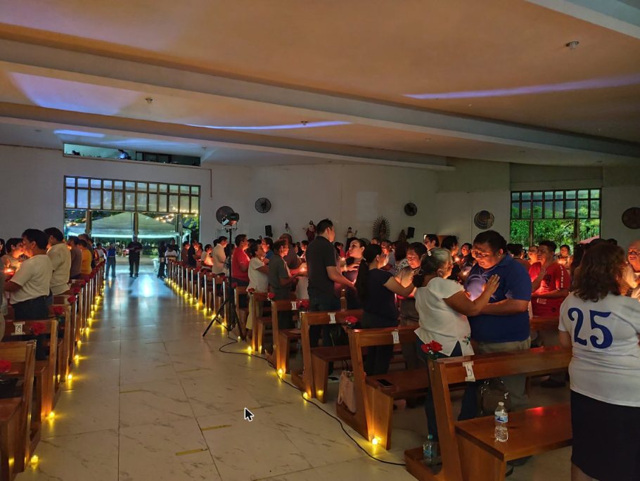 Interior del templo de la Parroquia San Juan Pablo II con matrimonios y velas encendidas